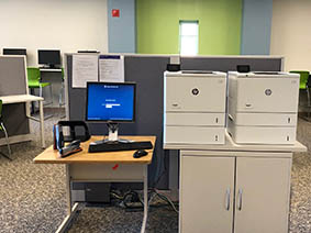 View of two printers side by side in front of window