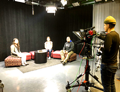 Group of students on ottoman in front of camera