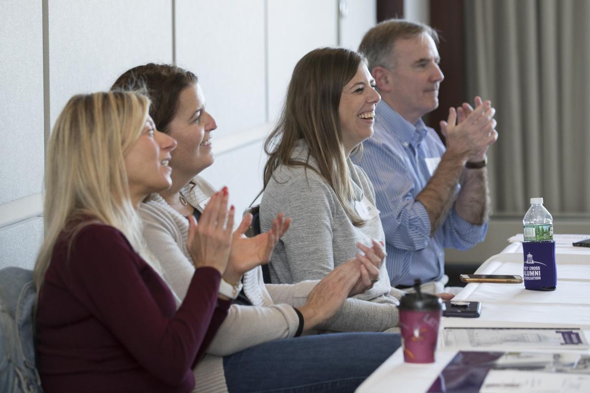 Four people watching a presentation and applauding