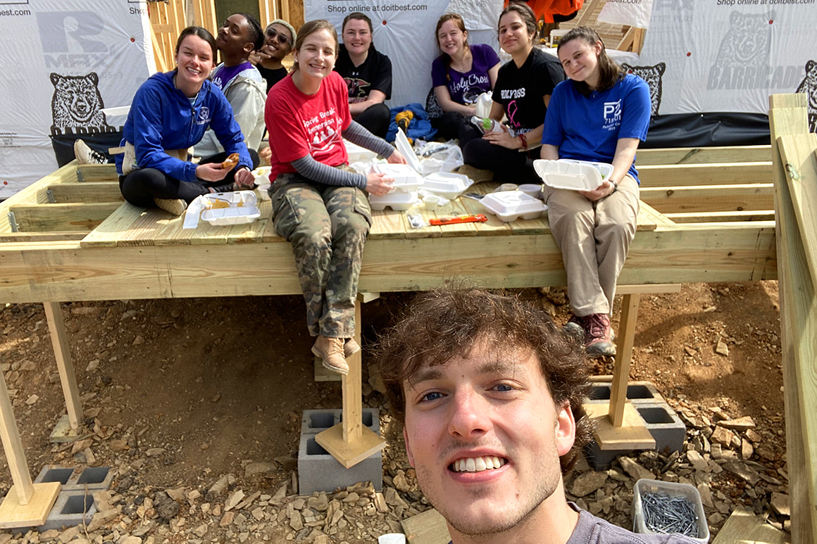 Students taking a lunch break at a construction site as part of an immersion program.