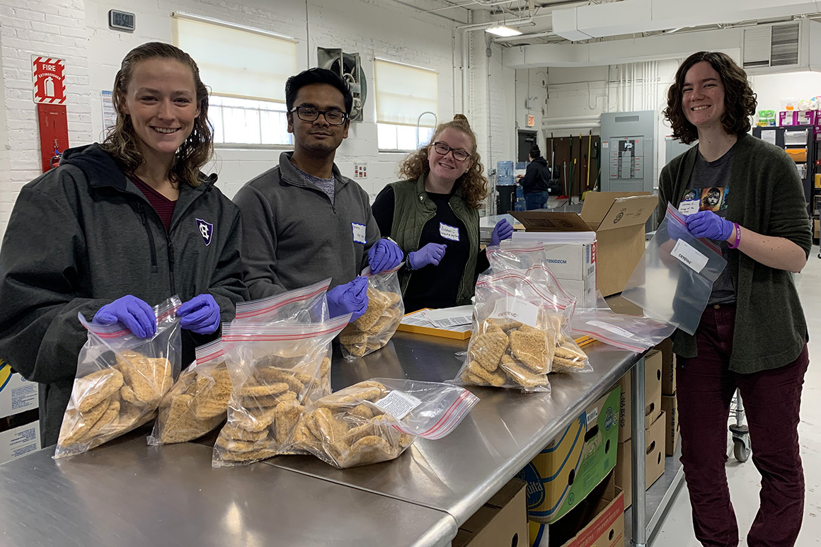 Students packing food in Ziploc bags at a food pantry as part of an immersion program.