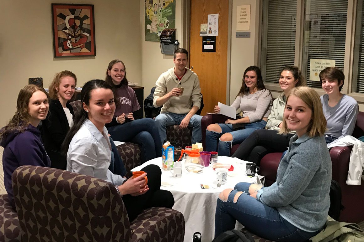 students sitting around a table with a table cloth