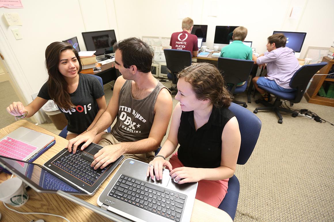 three students on laptops