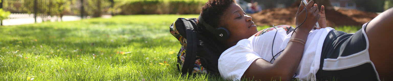 student laying on the grass 