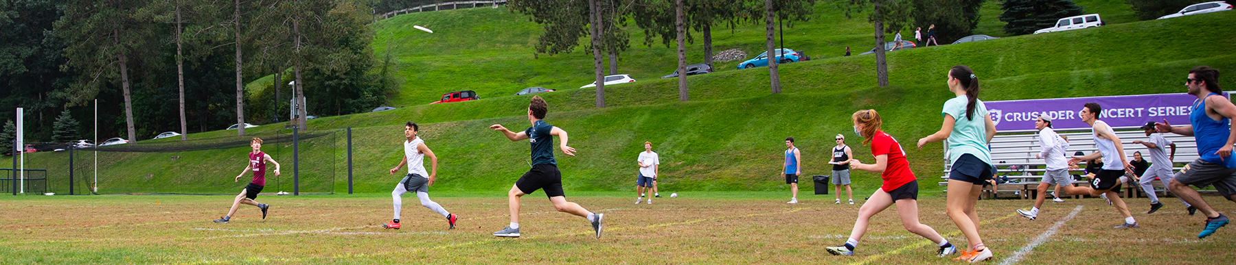 Holy Cross students playing co-ed frisbee on Freshman Field