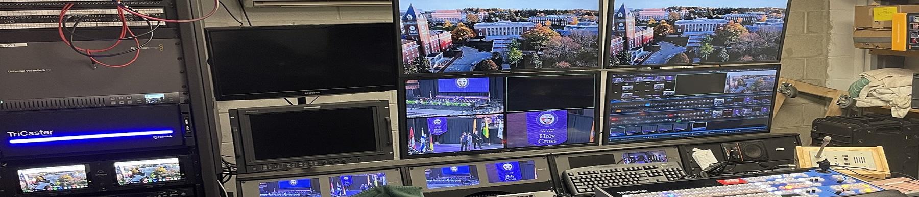 image of many computer monitors with different views of holy cross buildings