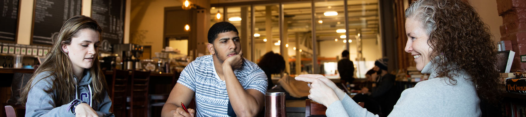 students sitting with a faculty member at a table 