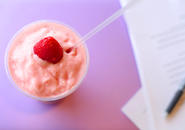 Strawberry smoothie with a whole strawberry on top.