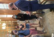 Congressman Jim McGovern, right, stands to speak with three students gathered around him after the event in Rehm Library. All are wearing face masks.