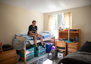 student sitting on his bed in williams hall