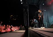 Two rockers on stage at a show with the audience cheering them on.