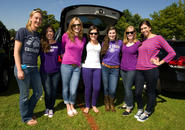 Group of seven women posing for a photo in the sunshine.