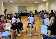 A group of students participating in an orientation event in a conference room