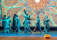 The company dances with a rooster.