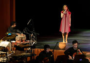 Jazz singer on stage; orchestra in the pit.