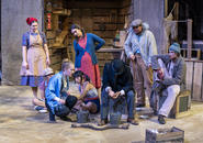 Shen Te comforts Wang, the water carrier.