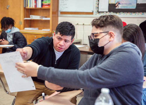 Josh Delgado '15 is reviewing classwork with a student from his Honors Algebra II class.