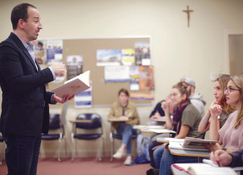 Jonathan Mulrooney speaks in front of a classroom full of students