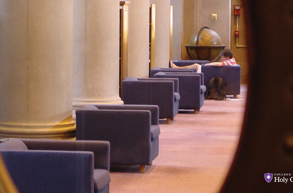 Photo of a student in the library, taken through a window