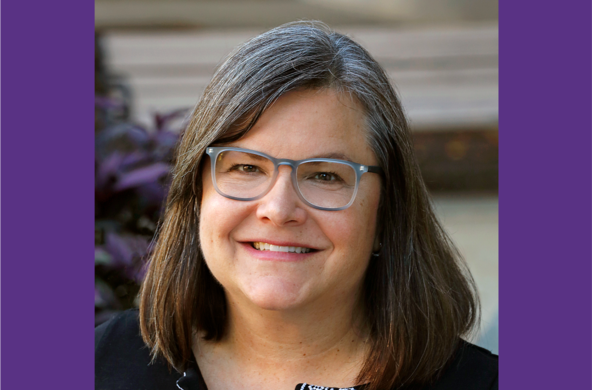 Stephanie Yuhl. She has salt and pepper hair parted on the side. Stephanie is wearing dark gray rimmed glasses and is smiling.