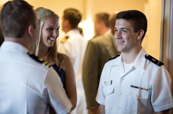 Three people talking, two of whom are in military uniform