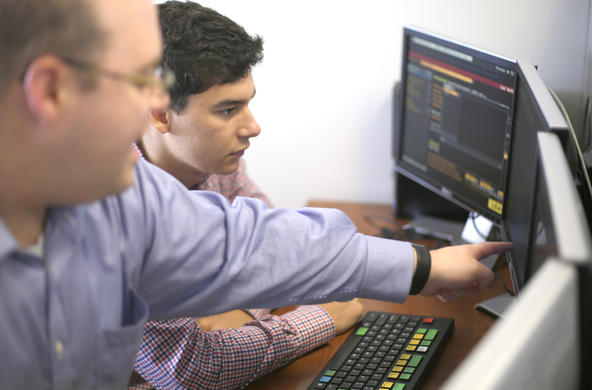 Two people looking at a computer screen on a desk
