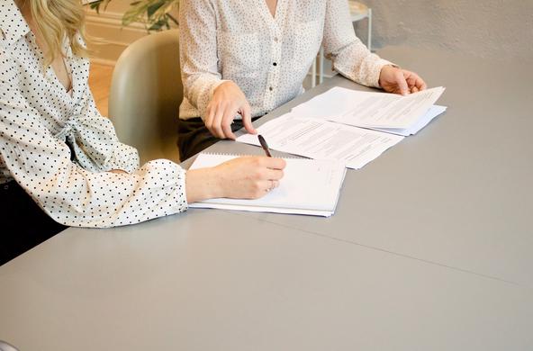 Two people sitting and reviewing documents