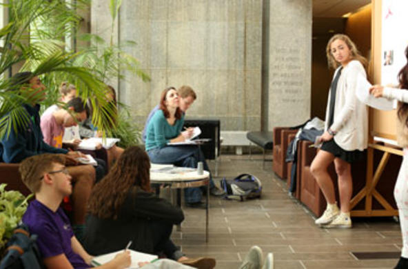 students present before professor and classmates at smith hall entrance