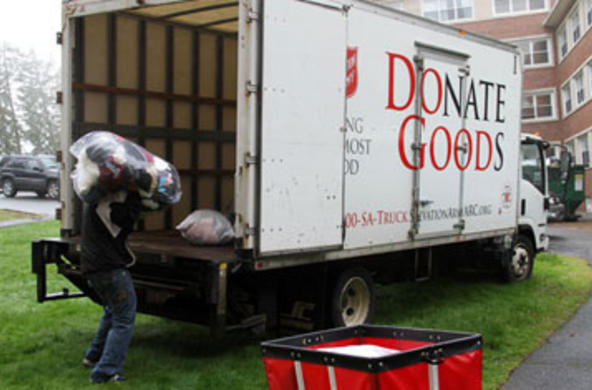 man from salvation army collecting a bag of used clothing 
