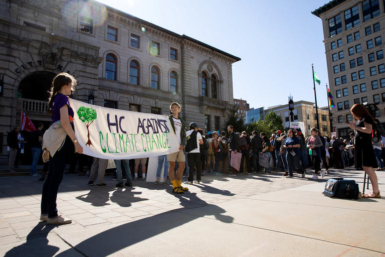 students outside City Hall with a banner