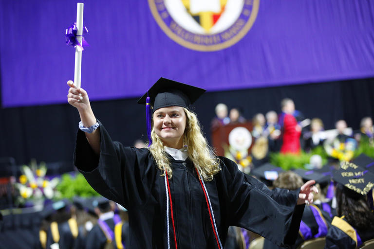 student holding up diploma during Commencement Exercises