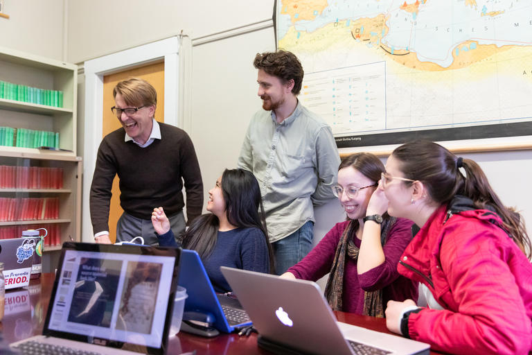 classics professor interacting with a group of students