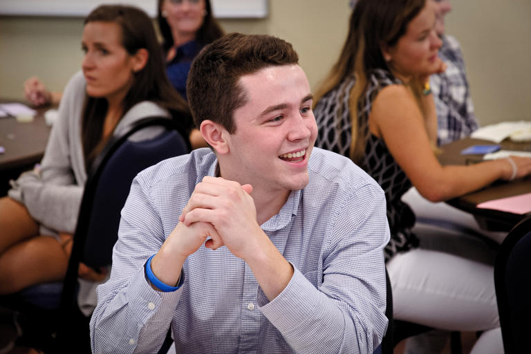 student smiling and looking to his left