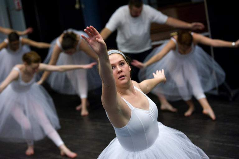 student wearing a tutu and practicing ballet in dance class