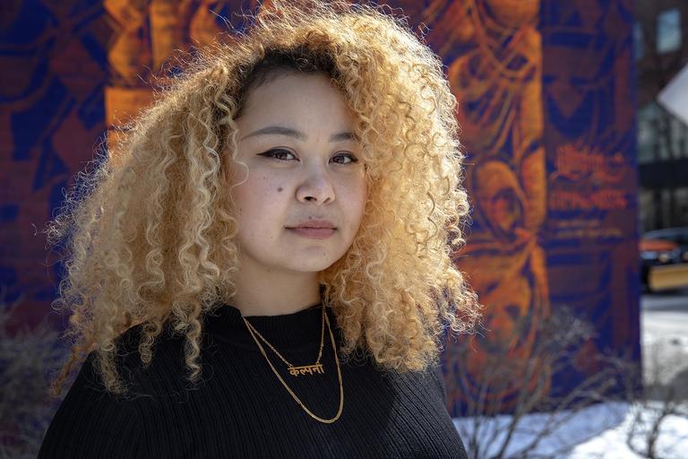 Portrait of artist outdoors in front of her artwork