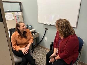 Two women in office cubicle talking
