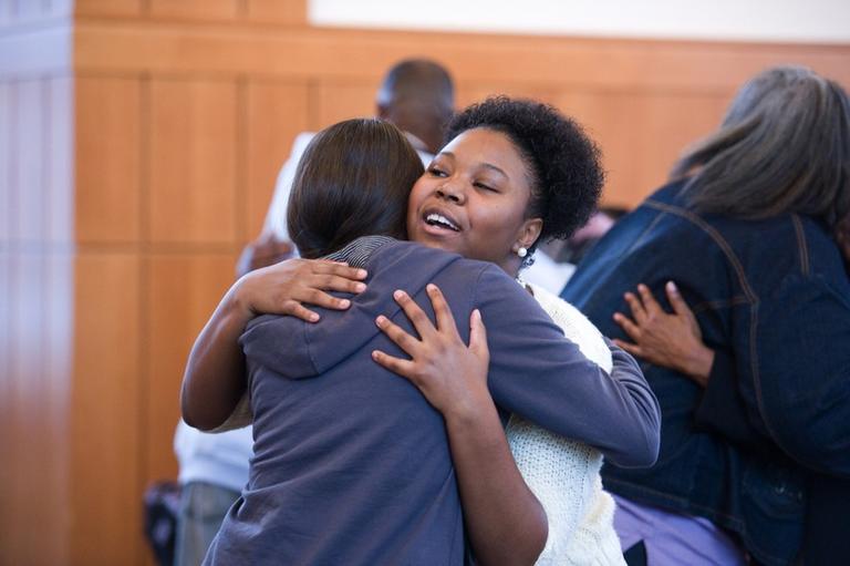 Two people hugging each other.