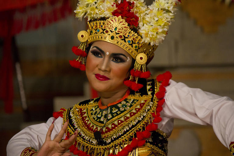 A Balinese performer wearing beautifully ornate and colorful clothing.