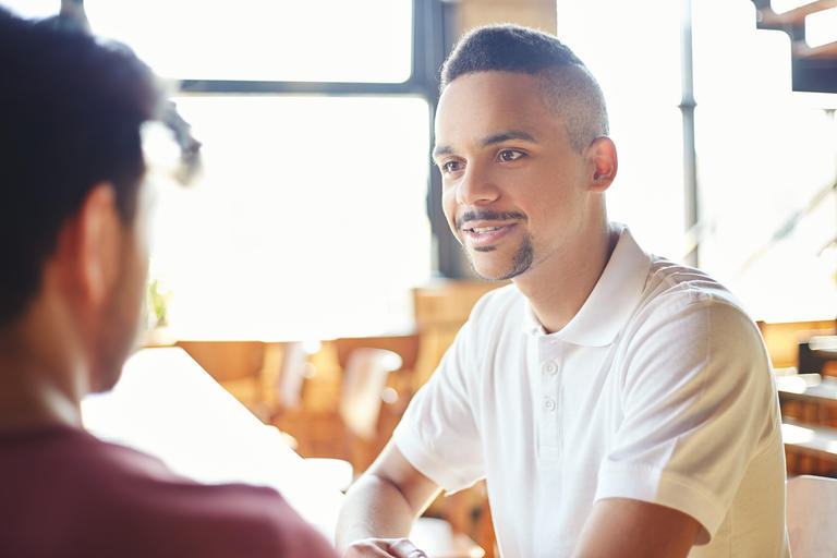 Two people talking at a table.