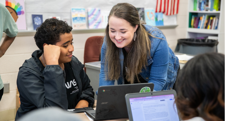 Counselor helping student at their laptop.
