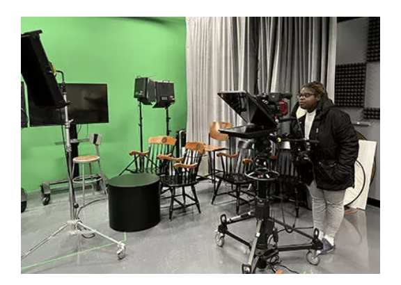 Student peeing into camera in studio