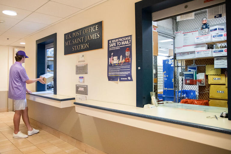 student at a post office window
