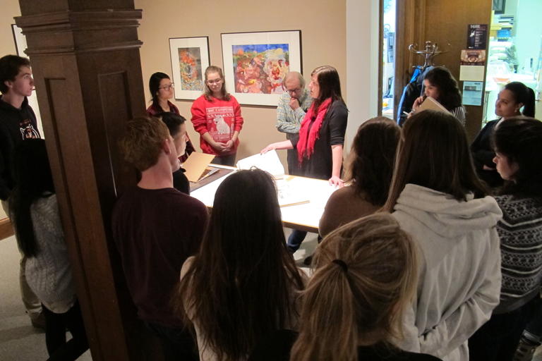 Professor Leslie Schomp working with drawing students in the gallery