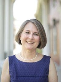 headshot woman with short hair and blue sleeveless dress