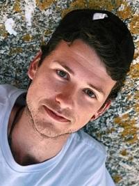 student with black cap smiling