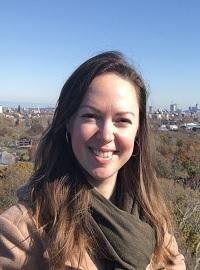smiling brown hair student in brown coat