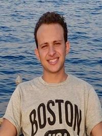 curly brown student smiling in khaki shirt