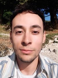 black hair student smiling with a blue shirt