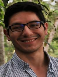 black hair student smiling with bleu shirt