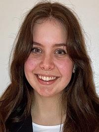 brown hair student smiling with black and white shirt
